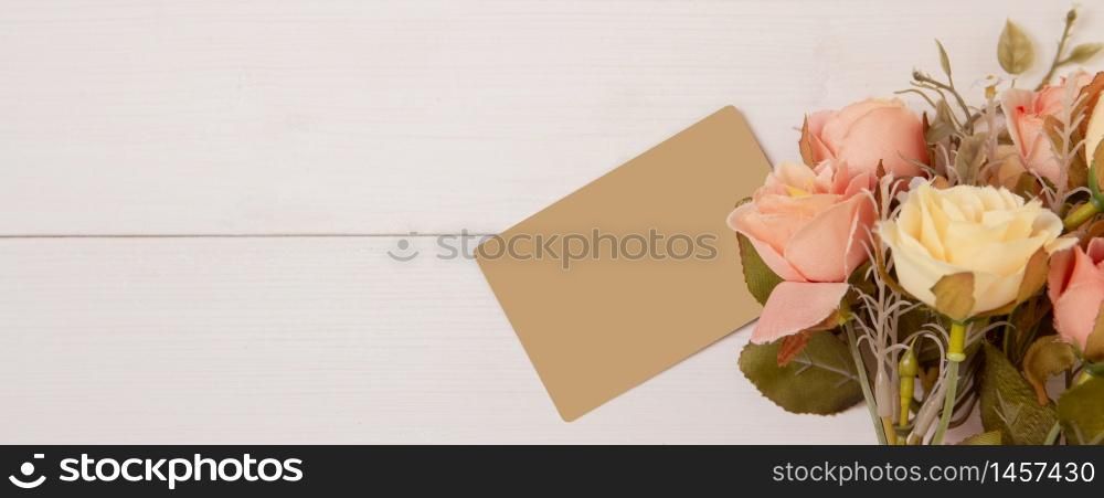 Beautiful flower and tag on wooden background with romantic, mother day or valentine day with pastel tone, nature background for decoration, floral for gift on desk, holiday concept, banner website.