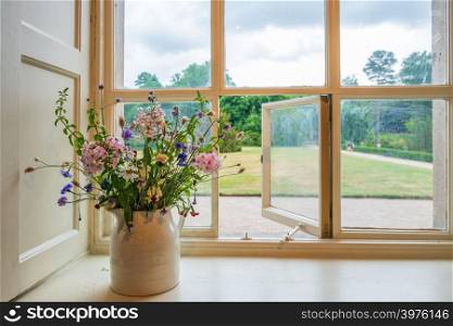 Beautiful flowers and window view into gardens from a traditional English stately home