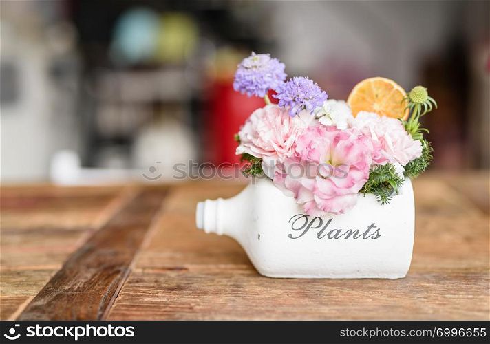 beautiful flowers in white bottle pot