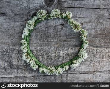 Beautiful flowers of clover lying on unpainted boards. Solemn event. Place for your inscription. Top view, close-up. Congratulations to loved ones, family, relatives, friends and colleagues. Beautiful flowers of clover lying on boards