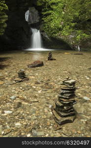 Beautiful flowing waterfall with magical fairy tale feel in lush green forest setting