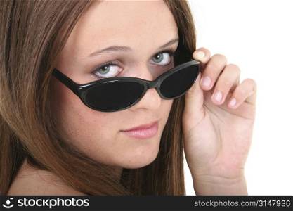 Beautiful Fourteen Year Old Girl Looking Over Sunglasses. Brown hair and hazel eyes.
