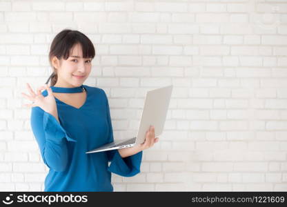 Beautiful freelance young asian woman confident using laptop computer online internet with success, blogger girl expression of excited with achievement from work and having proud in triumph.