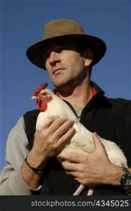 beautiful french man with hat and his white chicken