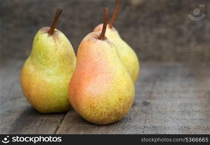 Beautiful fresh pears in rustic wooden setting
