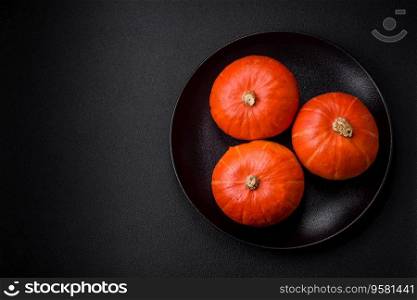 Beautiful fresh round pumpkins in oran≥color on a dark concrete background. Preparing for the Halloween ce≤bration
