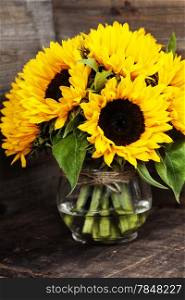 Beautiful fresh Sunflowers in vase on wooden background