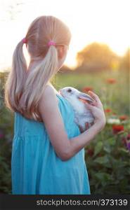 beautiful fun blond girl and rabbit on a sunny summer day
