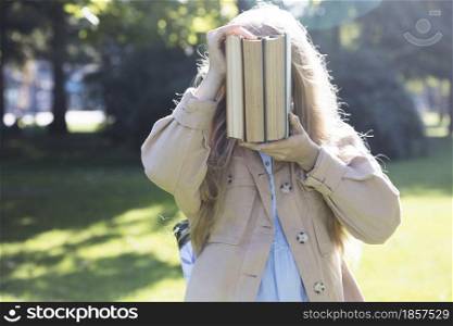 beautiful fun schoolgirl with a backpack and books outdoor