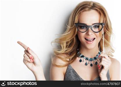 Beautiful funny woman with party paper glasses on stick showing empty copy space, white background