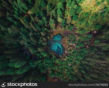 Beautiful Geyser (blue, silver) lake with thermal springs that periodically throw blue clay and silt from the ground. Aerial drone view. Aktash, Altai mountains, Russia. Geyser (blue, silver) lake with thermal springs