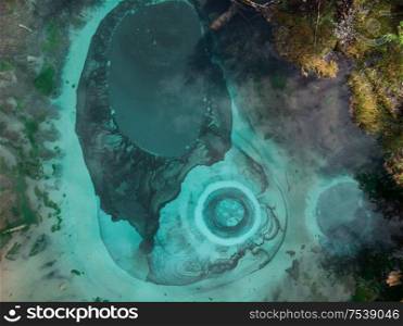 Beautiful Geyser lake with thermal springs that periodically throw blue clay and silt from the ground. Aerial drone view. Aktash, Altai mountains, Russia. Geyser lake with thermal springs