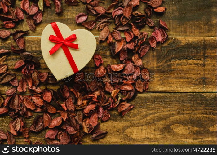 Beautiful gift with red ribbon around dry petals