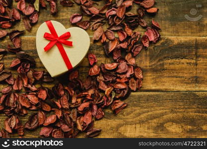 Beautiful gift with red ribbon around dry petals