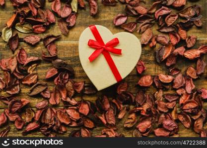 Beautiful gift with red ribbon around dry petals