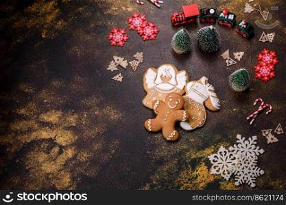 Beautiful gingerbread on a brown ceramic plate with Christmas tree decorations on a dark concrete background. Getting home ready for Christmas. Beautiful gingerbread on a brown ceramic plate with Christmas tree decorations