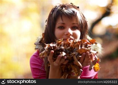 Beautiful girl&acute;s portrait with leaves in the autumn park