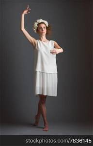 Beautiful girl, ballet dancer wearing white dress, gray background