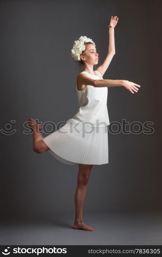 Beautiful girl, ballet dancer wearing white dress, gray background