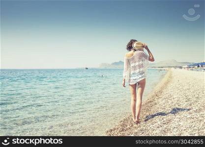 Beautiful girl bathed in sunshine walking on the beach. Beautiful girl bathed in sunshine.