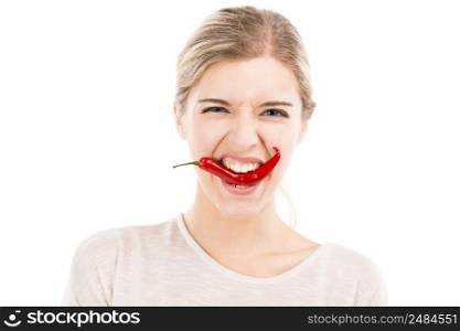 Beautiful girl biting a red chilli pepper, isolated over a white background