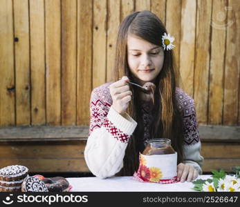 beautiful girl eating melted chocolate jar table
