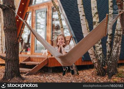 Beautiful girl enjoying autumn day outdoors. Beautiful girl having fun in hammock at autumn warm day