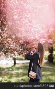 beautiful girl enjoys the scent of flowering tree. Portrait of beautiful woman with blooming cherry tree - girl inhales the scent of flowers with closed eyes - spring, nature and beauty concept.. beautiful girl enjoys the scent of flowering tree. Portrait of beautiful woman with blooming cherry tree - girl inhales the scent of flowers with closed eyes - spring, nature and beauty concept