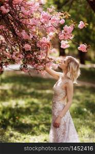 beautiful girl enjoys the scent of flowering tree. Portrait of beautiful woman with blooming cherry tree - girl inhales the scent of flowers with closed eyes - spring, nature and beauty concept. beautiful girl enjoys the scent of flowering tree. Portrait of beautiful woman with blooming cherry tree - girl inhales the scent of flowers with closed eyes - spring, nature and beauty concept.