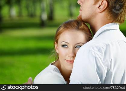Beautiful girl gently nestles on a man&rsquo;s breast in a summer garden
