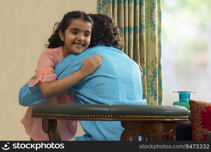 Beautiful girl hugging her father sitting on char at home