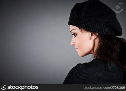 beautiful girl in a beret on the dark