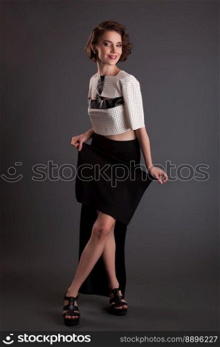 beautiful girl in a black skirt and a white jacket model posing on a black background vintage