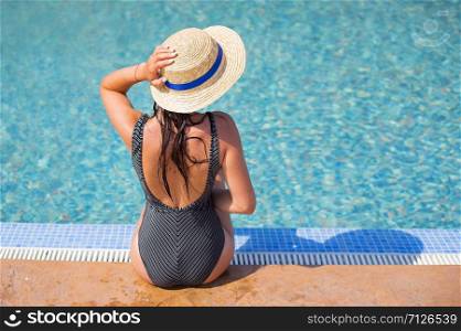 Beautiful girl in a black swimsuit near a blue pool-summer, sun, vacation.. Beautiful girl in a black swimsuit near a blue pool-summer, sun, vacation