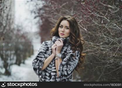Beautiful girl in a fur coat on a winter walk.. Portrait of a girl on a winter walk 4972.