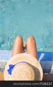 Beautiful girl in a hat near a blue pool - sun, summer, heat.. Beautiful girl in a hat near a blue pool - sun, summer, heat