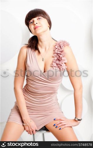 beautiful girl in a pink dress on a white wall