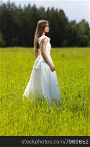 Beautiful girl in a wedding dress in the field