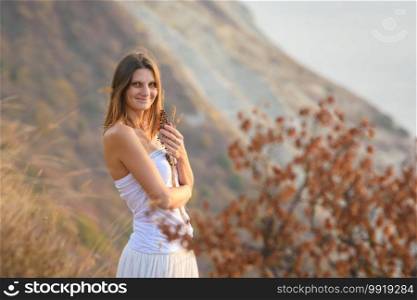 Beautiful girl in a white dress on a background of mountains