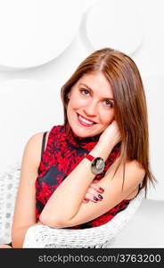 beautiful girl in a white wicker chair smiling