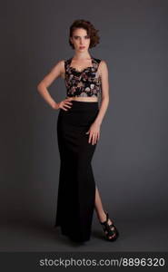 beautiful girl in black skirt model posing on a black background