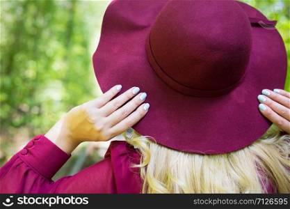 beautiful girl in cherry dress with a hat in the woods. close up. beautiful girl in cherry dress with a hat in the woods.