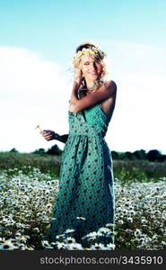 beautiful girl in dress on the daisy flowers field