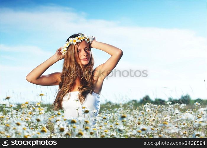 beautiful girl in dress on the daisy flowers field