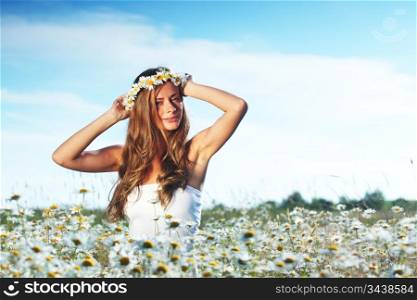 beautiful girl in dress on the daisy flowers field