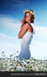 beautiful girl in dress on the daisy flowers field