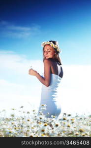 beautiful girl in dress on the daisy flowers field