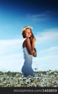 beautiful girl in dress on the daisy flowers field