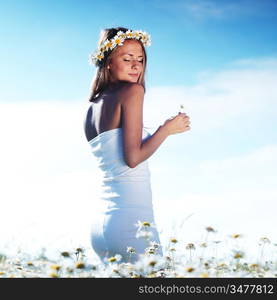 beautiful girl in dress on the daisy flowers field