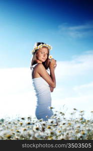 beautiful girl in dress on the daisy flowers field